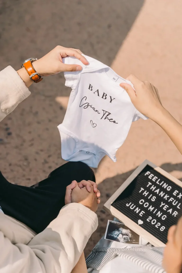 Expecting parents holding a baby onesie and pregnancy announcement sign during their Seoul photoshoot