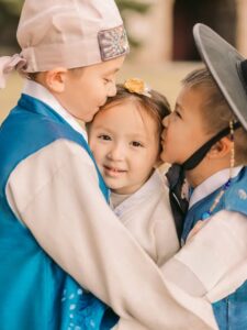 Family sharing a sweet moment while wearing traditional Korean hanbok in Seoul