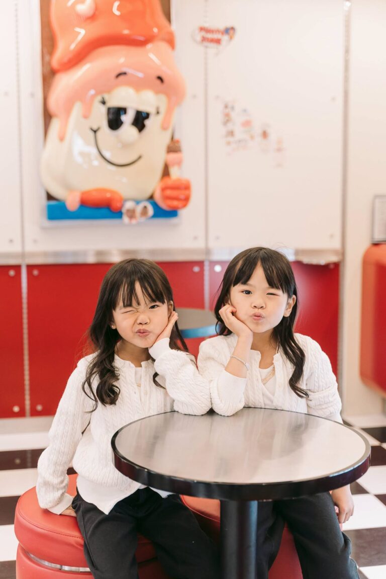 Two young sisters posing together during a candid children’s photoshoot in Seoul