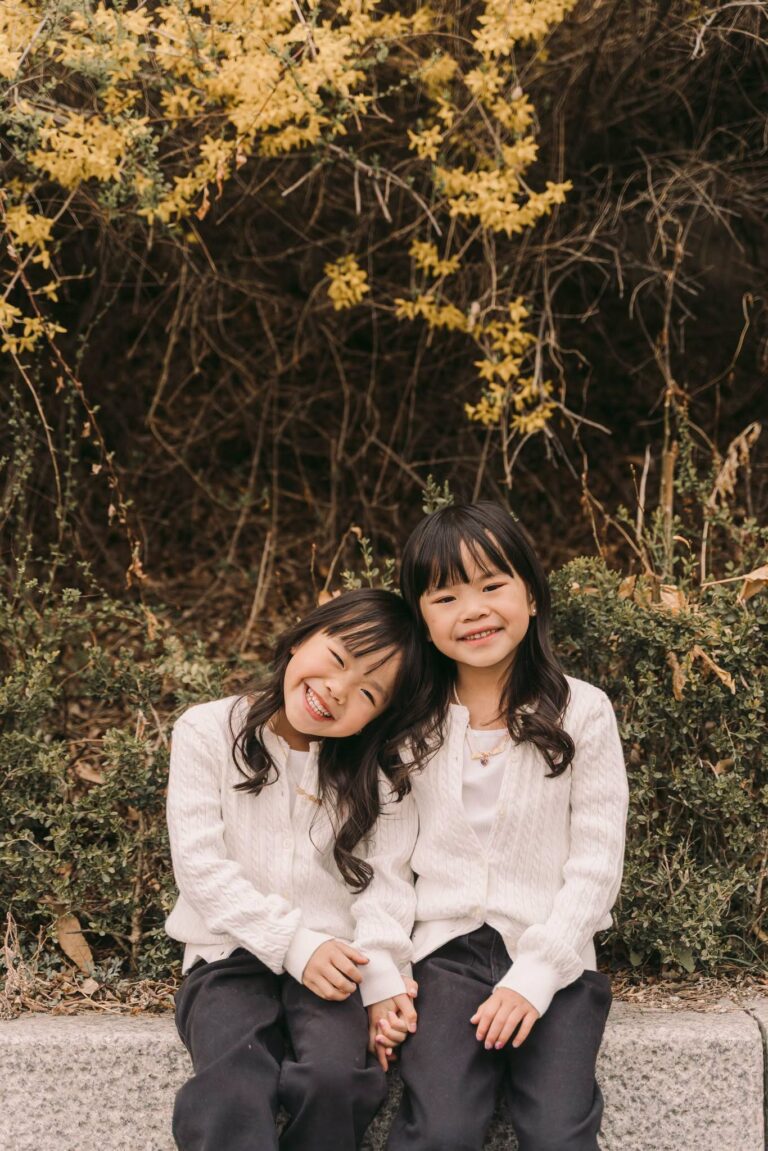Two sisters smiling together during an outdoor portrait session in Seoul