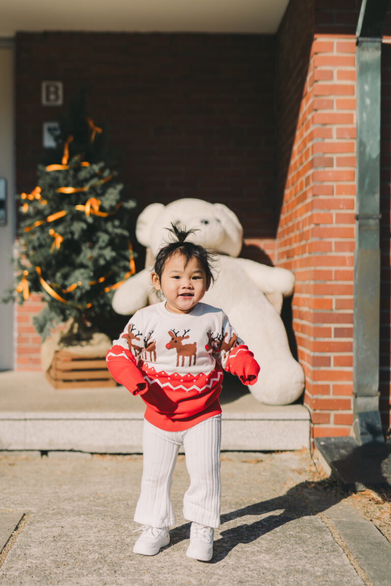 Smiling child in a Christmas sweater during a holiday photoshoot in Seoul