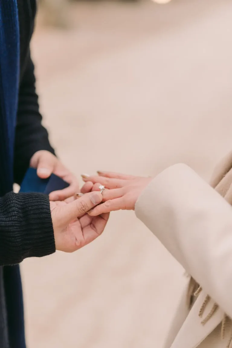 Close-up of a newly engaged couple holding hands and showing an engagement ring