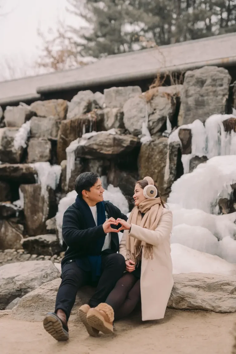Newly engaged couple celebrating beside a frozen waterfall in Seoul