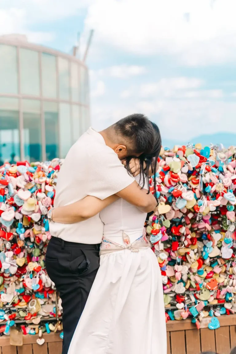 Couple embracing beside colorful love locks during their Seoul photography session