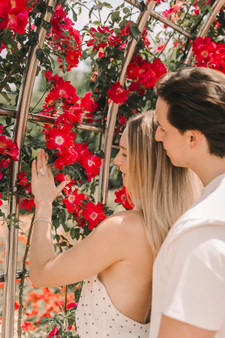 Engaged couple admiring a ring during a colorful rose garden photoshoot in Seoul