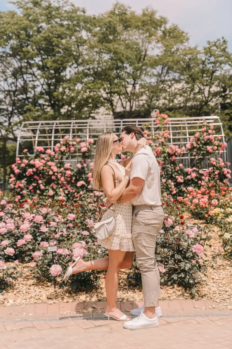 Romantic couple kissing among blooming roses during a Seoul photoshoot