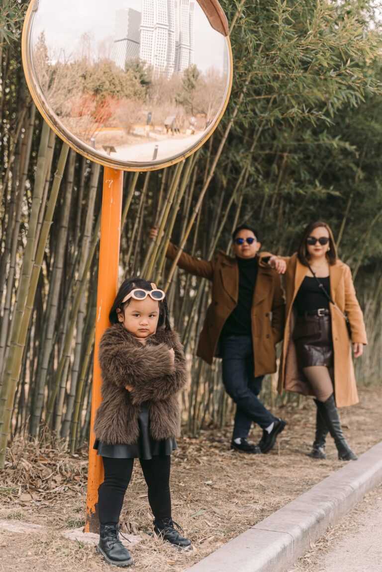 Parents and young child walking together beside bamboo during a family trip in Korea