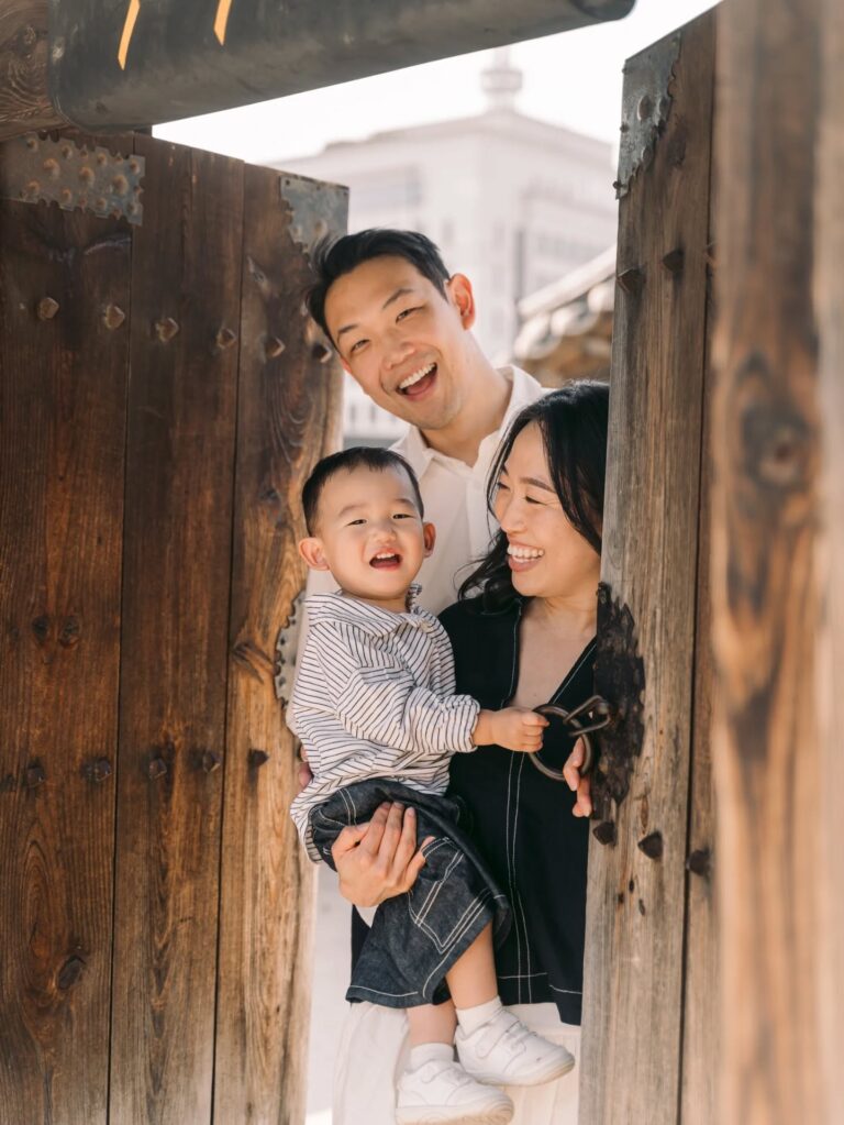 Parents laughing with their young child during a candid family portrait session in Seoul