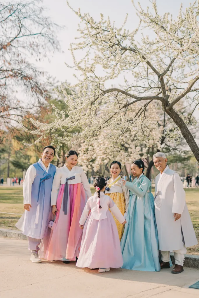 Family wearing colorful traditional Korean hanbok during a spring photoshoot in Seoul