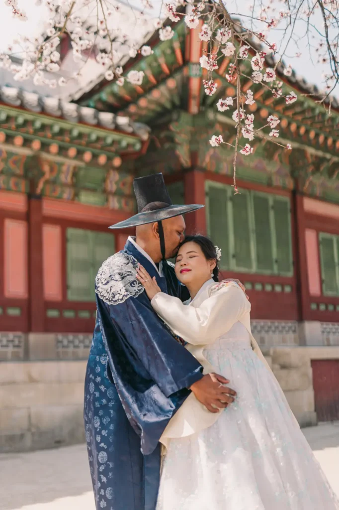 Couple embracing in blue and white traditional Korean hanbok at Gyeongbokgung Palace