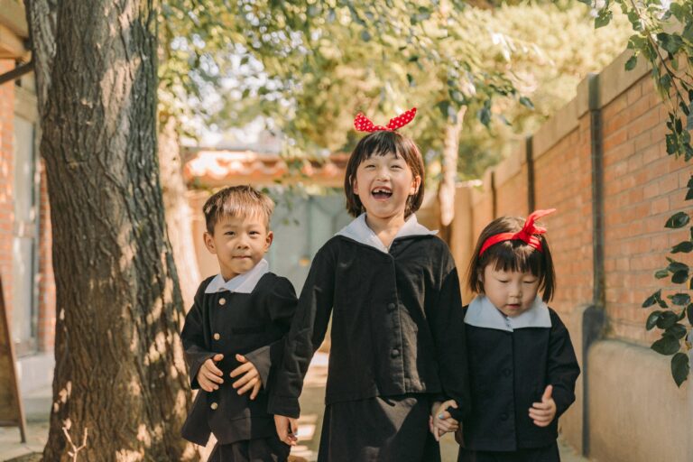 Three children walking together outdoors during a candid sibling photoshoot in Seoul.