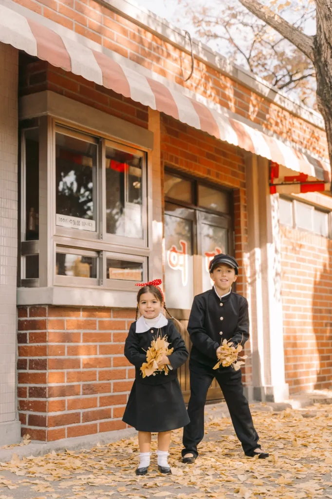 kids throwing ginko tree leaves in seoul