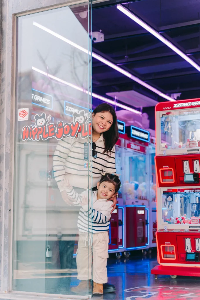 mom and daughter photo on the street in front of an arcade