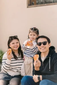Parents and their daughter enjoying snacks together during a family trip in Seoul